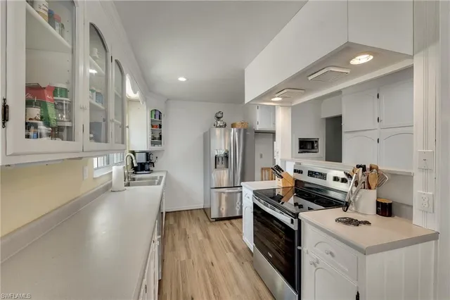 a kitchen with refrigerator a stove and wooden floor