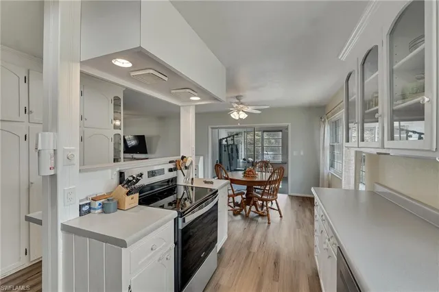 a kitchen with stainless steel appliances a stove top oven a sink a dining table and chairs