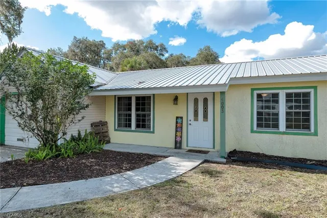 a front view of a house with a garden and yard