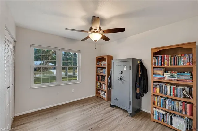 a view of a workspace with furniture window and a chandelier fan