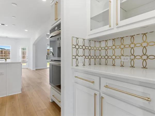 a kitchen with stainless steel appliances cabinets and a wooden floor