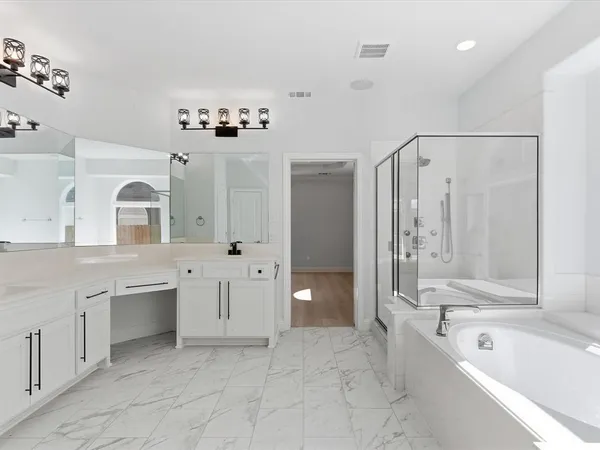 a spacious bathroom with a tub sink shower and mirror