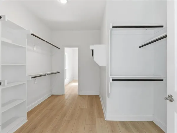 a view of a kitchen with a refrigerator and wooden floor