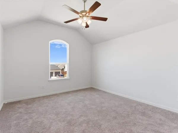 an empty room with a window and a fan