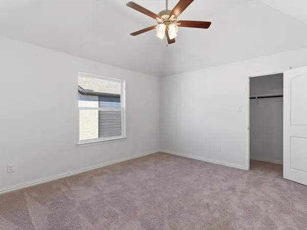 an empty room with a window and a fan