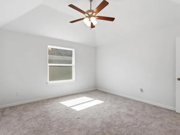 an empty room with a window and a fan