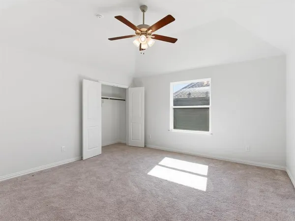 an empty room with windows and fan