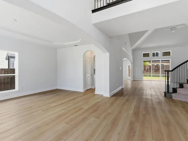 a view of empty room with wooden floor and window