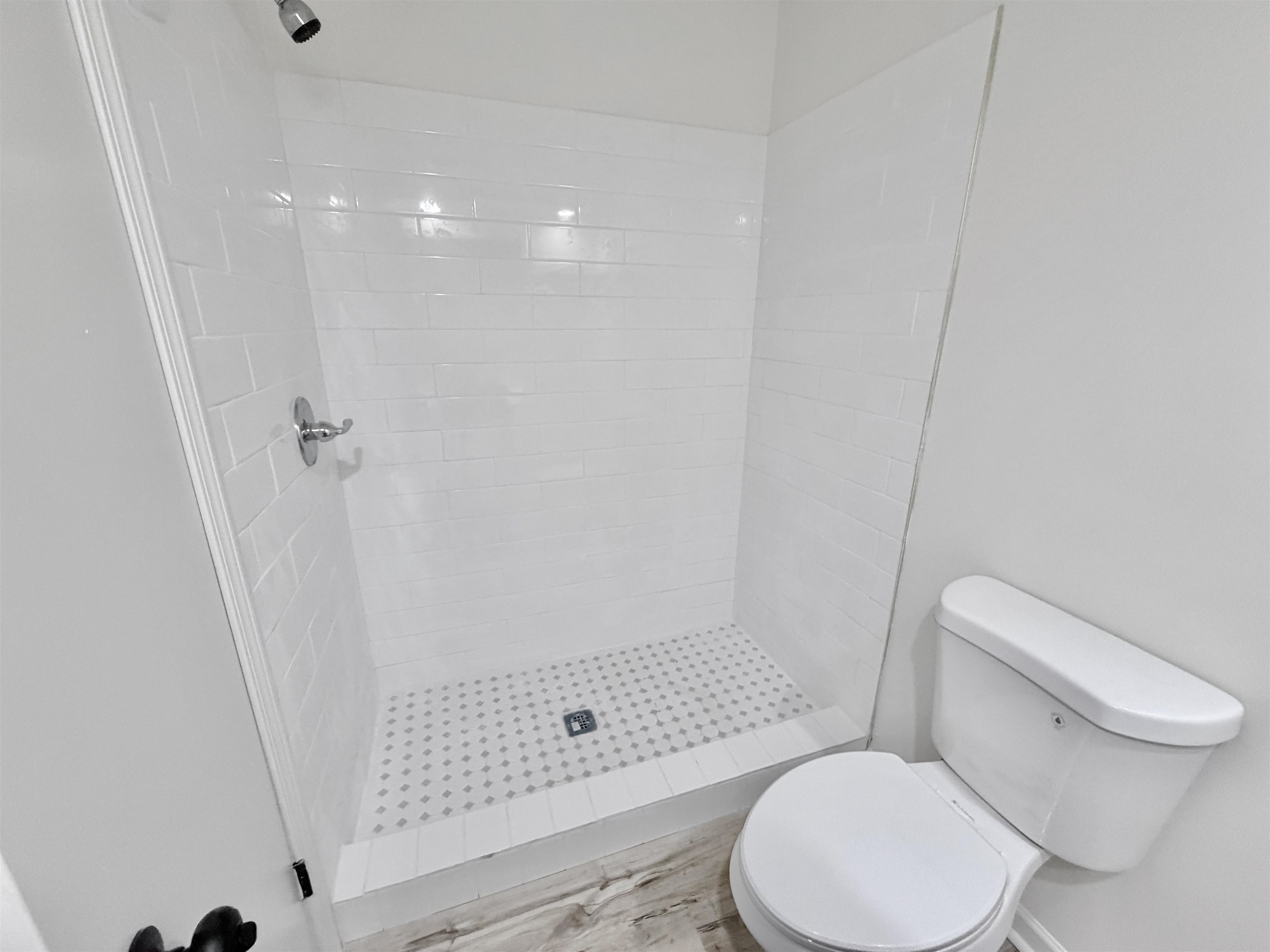 4278 Auburn Road Memphis, TN 38116 - Photo 16 of 28 Walk-in shower with white subway tile surround and a tiled floor with a decorative pattern