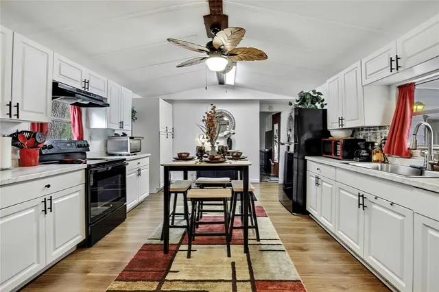 a kitchen with a dining table appliances and cabinets