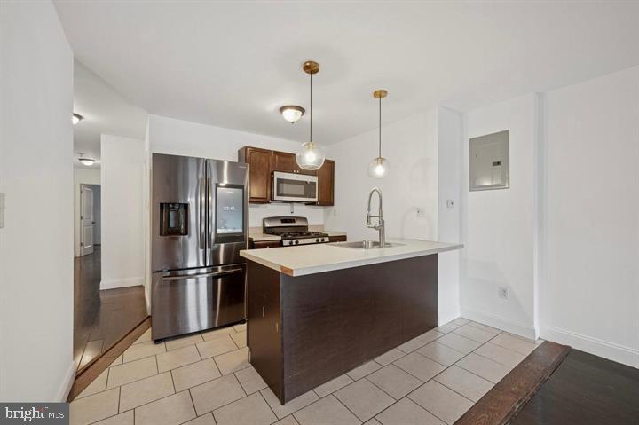 2467 79th Avenue, Unit 1 Philadelphia, PA 19150 - Photo 6 of 16 a kitchen with kitchen island a counter top space stainless steel appliances and cabinets