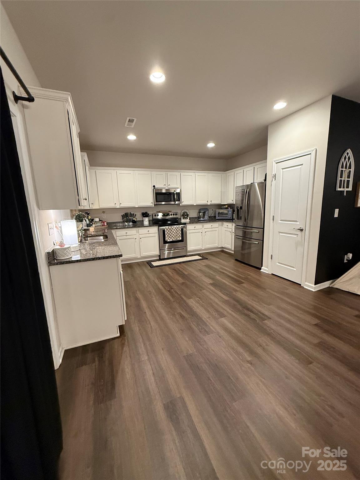115 Stoney Lane Cherryville, NC 28021 - Photo 16 of 27 a kitchen with stainless steel appliances a refrigerator a sink dishwasher and a stove top oven with wooden floor