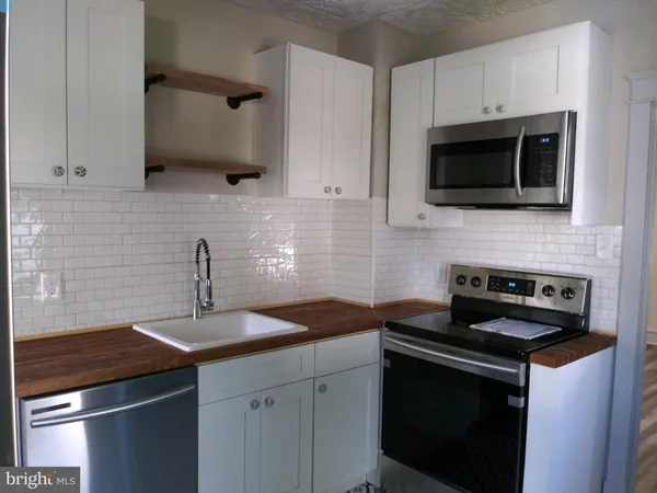 a kitchen with a sink stove and microwave