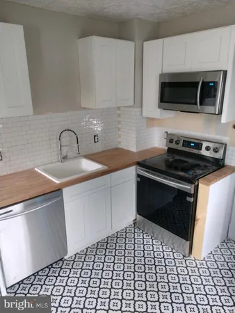 a kitchen with a sink and a stove top oven