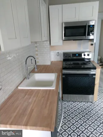 a kitchen with a sink and a stove top oven