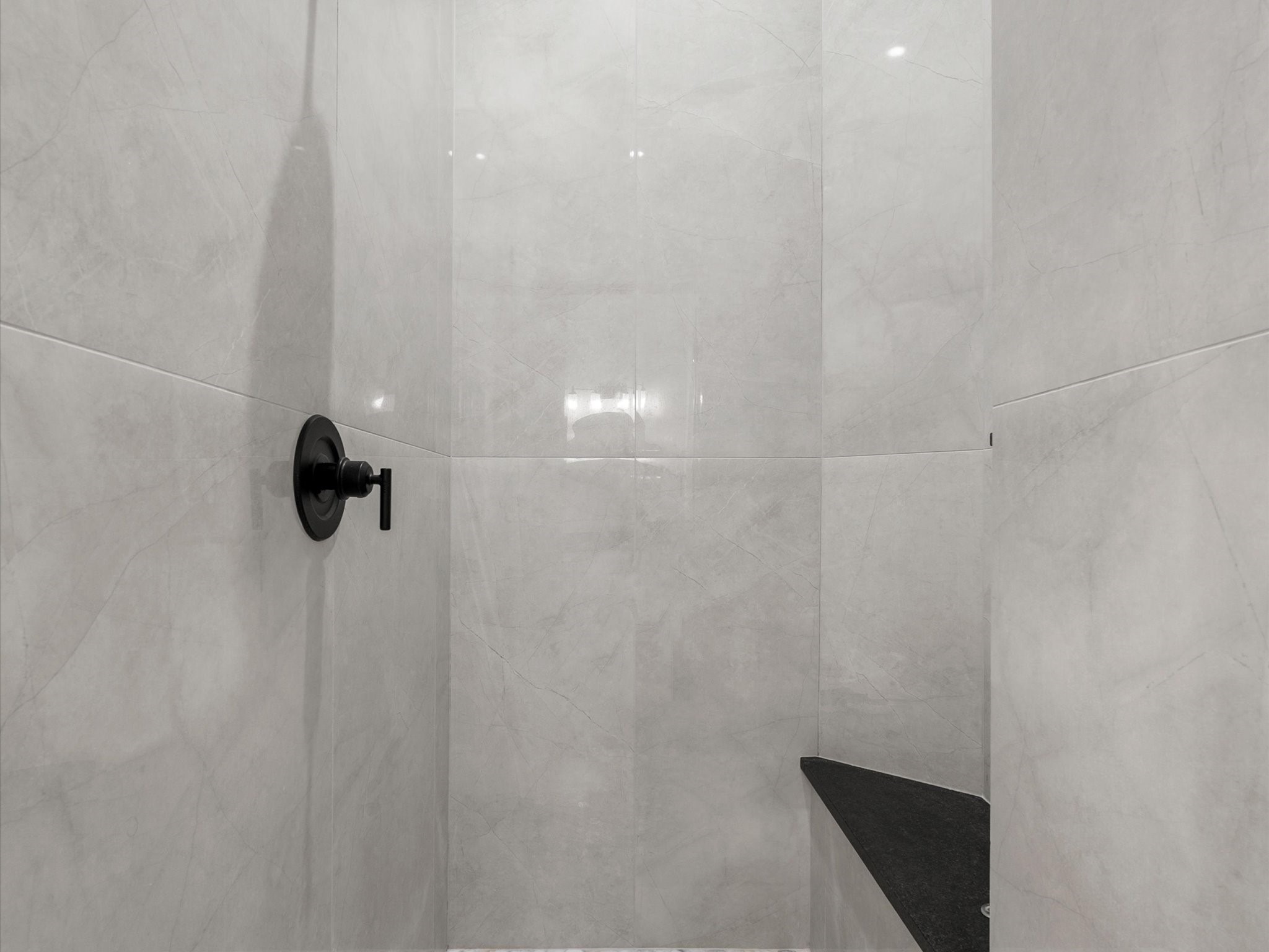 5910 Center Ct Drive Spring, TX 77379 - Photo 25 of 50 The walk-in shower is finished with elegant marble-look tile, adding a clean, polished aesthetic that reinforces the suite’s fully renovated, elevated design.