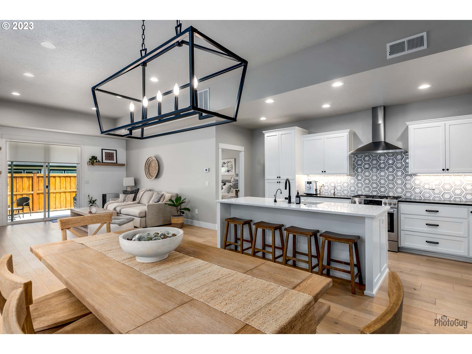 3561 Nestucca Loop Eugene, OR 97408 - Photo 7 of 29 a kitchen with stainless steel appliances kitchen island granite countertop a table chairs in it and wooden floors