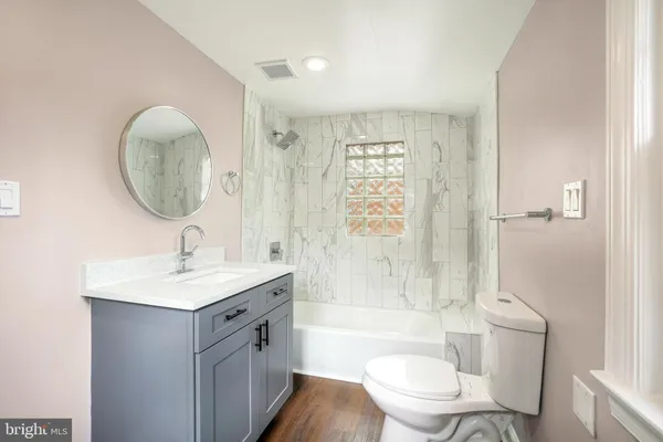 a bathroom with a granite countertop sink a toilet and shower