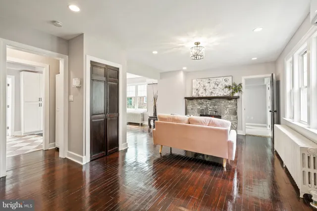 a large living room with a large window wooden floor and a ceiling fan