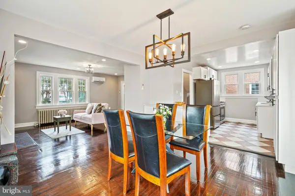 a view of a dining room with furniture a kitchen and chandelier