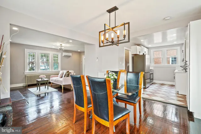a view of a dining room with furniture a kitchen and chandelier