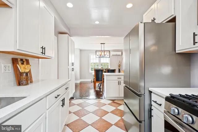 a kitchen with stainless steel appliances granite countertop a refrigerator and a stove top oven