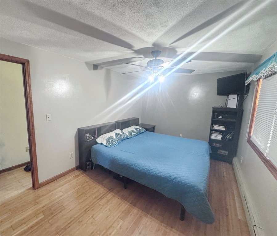 3 Stone Court Gloucester, MA 01930 - Photo 19 of 28 a bedroom with a bed and a chandelier