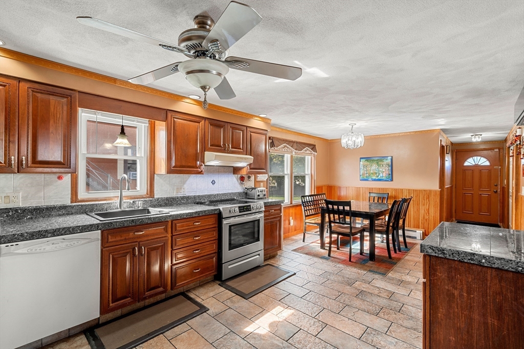 3 Stone Court Gloucester, MA 01930 - Photo 5 of 28 a kitchen with stainless steel appliances granite countertop wooden cabinets a dining table and chairs