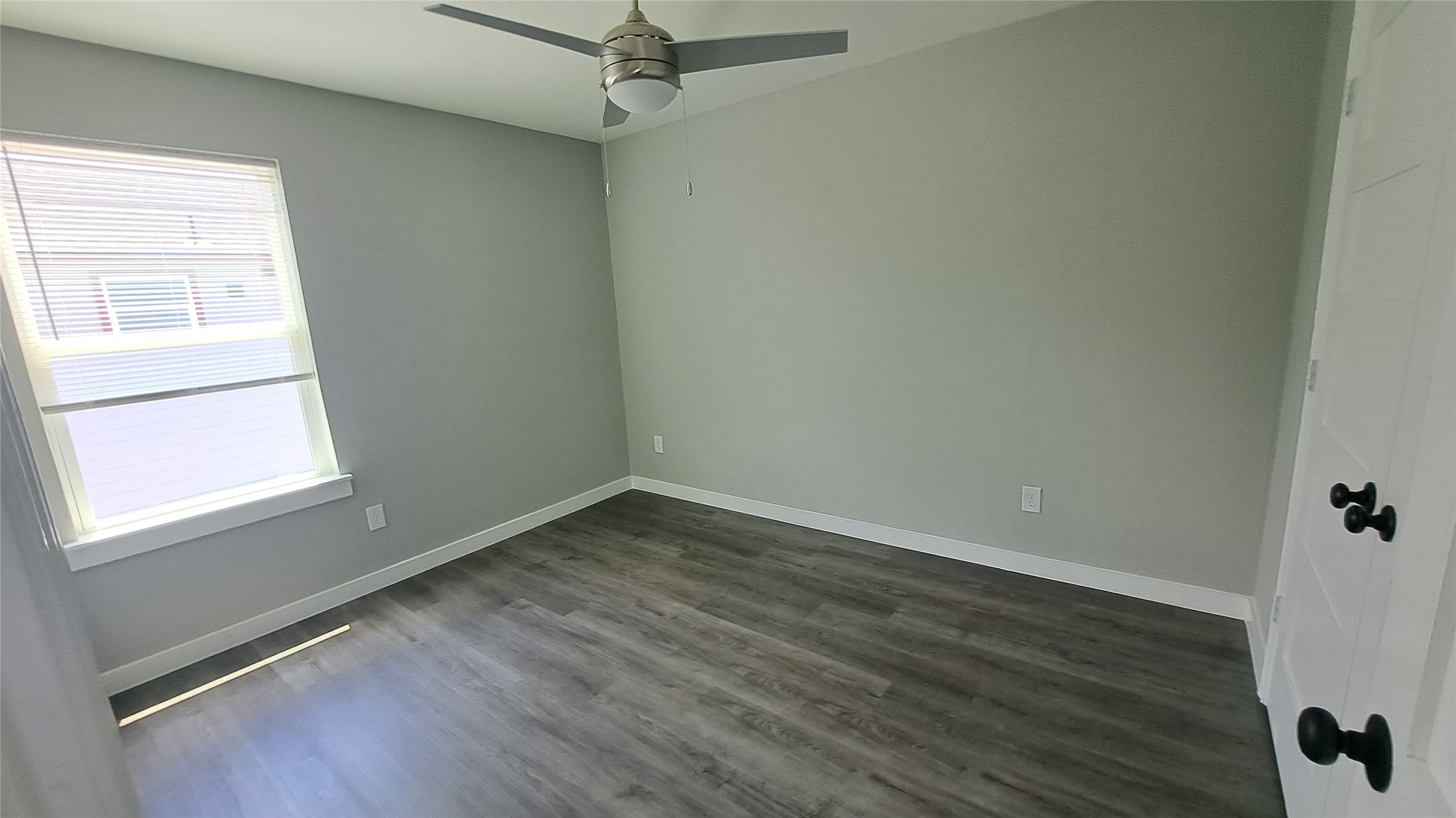 9806 Fillmore Street, Unit B Houston, TX 77029 - Photo 7 of 9 an empty room with wooden floor and windows