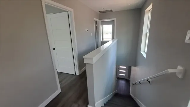 a view of a hallway with wooden floor and entryway