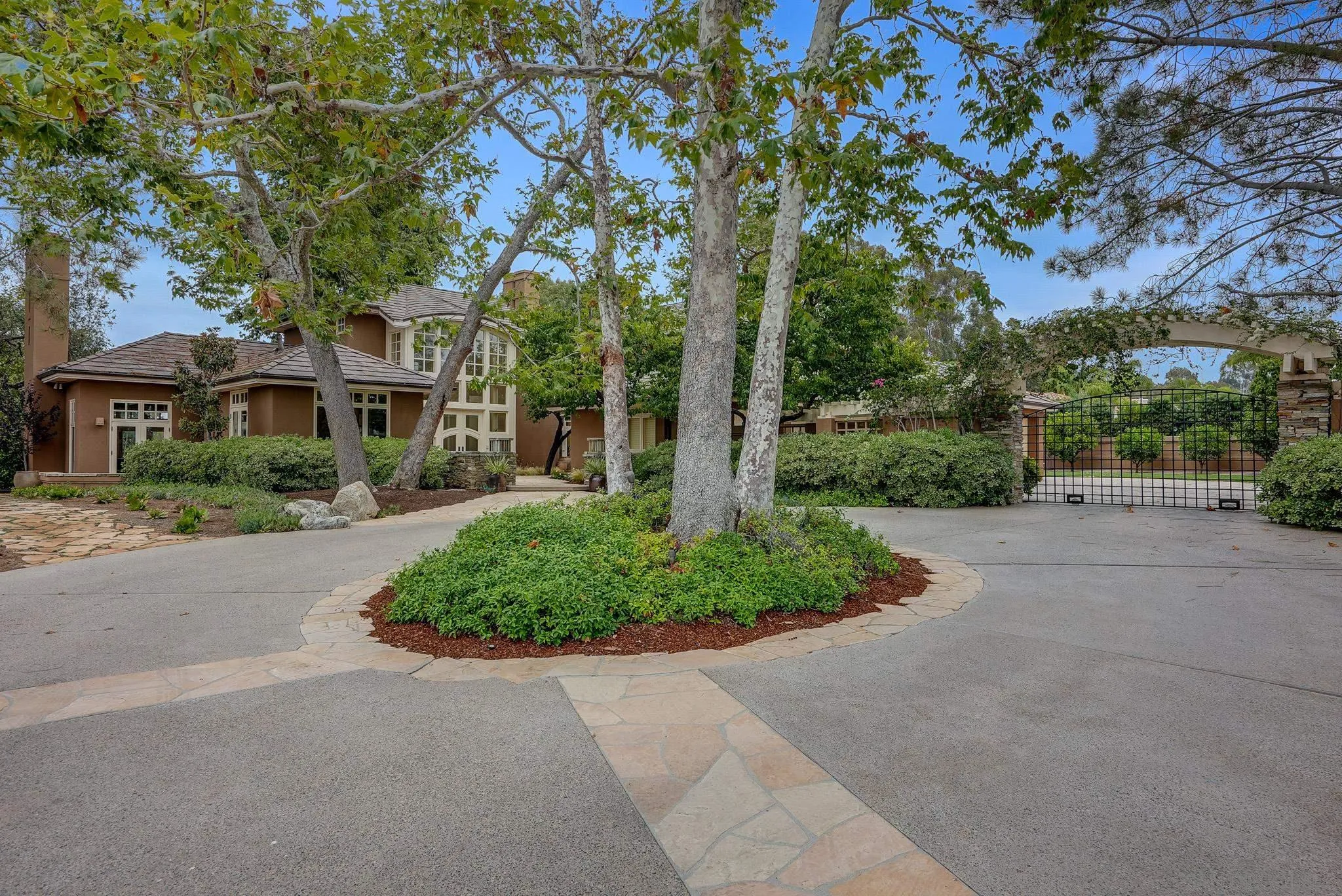 a front view of a house with a yard and potted plants