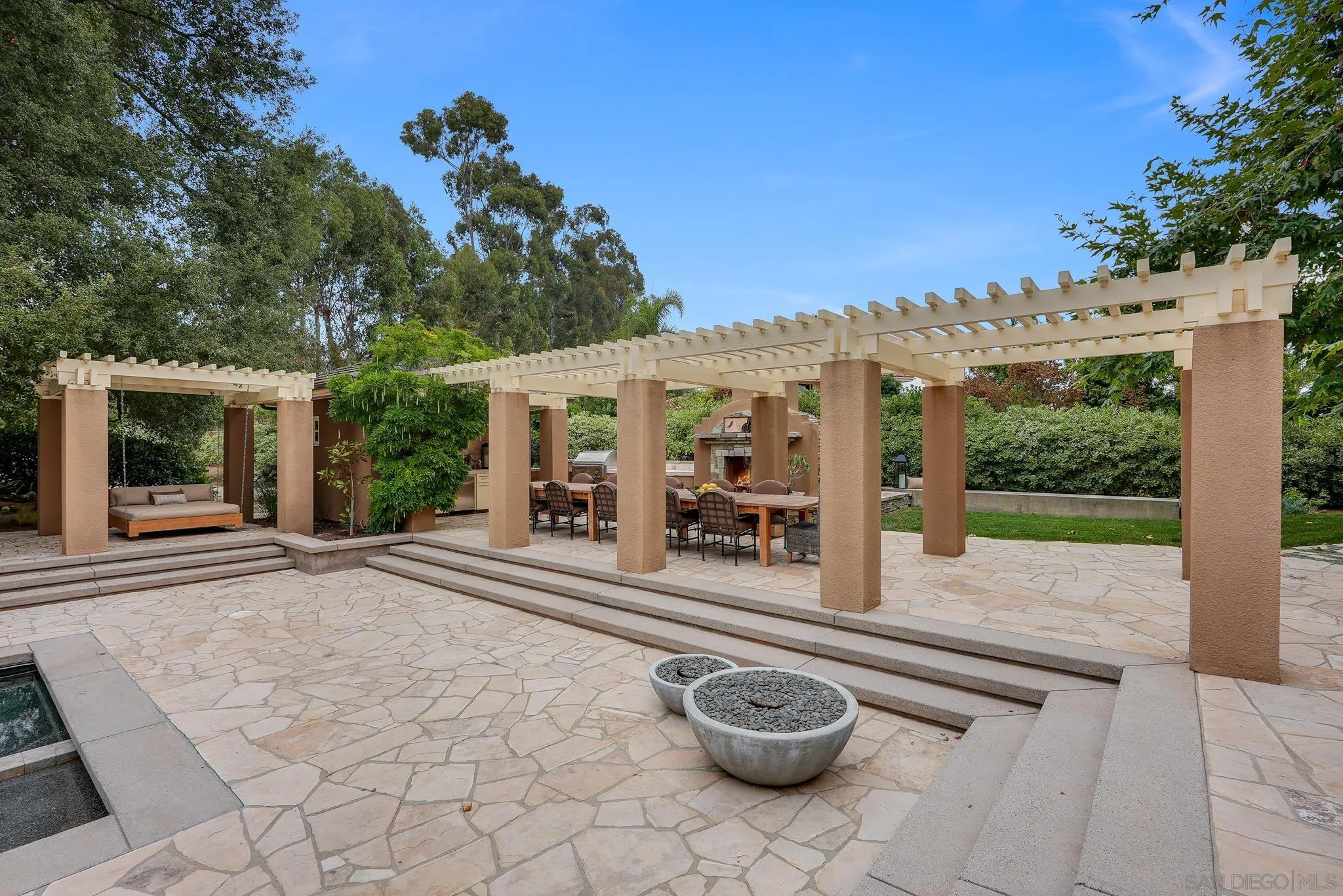 7891 Muirfield Way Rancho Santa Fe, CA 92067 - Photo 44 of 47 a view of a patio with table and chairs potted plants with wooden fence