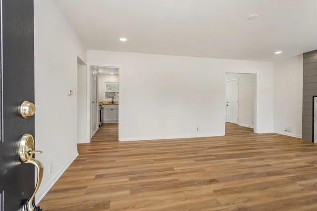 a view of an empty room with a fireplace and a window