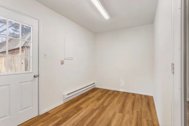 a view of a room with wooden floor and a hallway