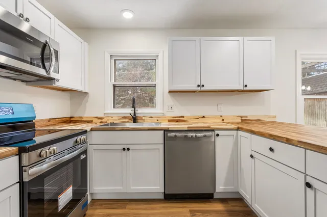 a kitchen with stainless steel appliances granite countertop a refrigerator stove top oven and sink