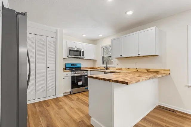 a kitchen with stainless steel appliances a stove and a microwave