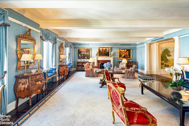 a very nice looking living room with a large window and potted plants