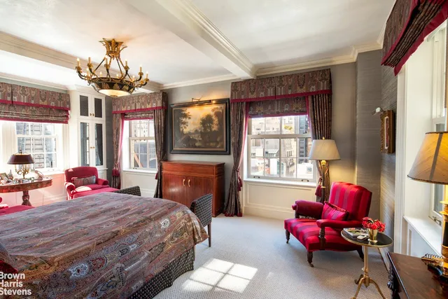 a bedroom with a bed and large windows