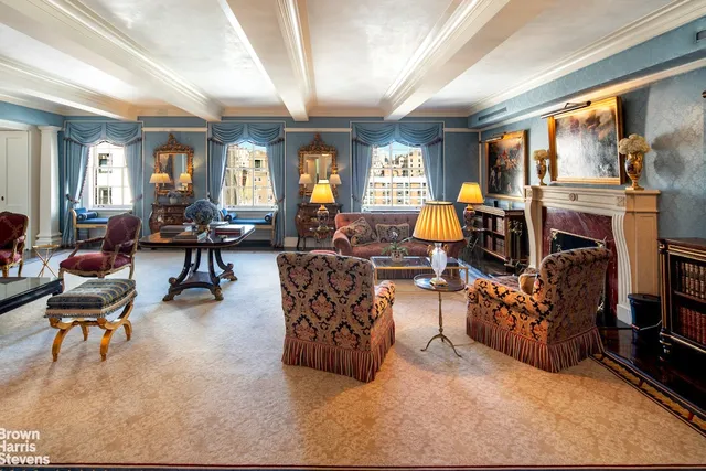 a living room with fireplace furniture and a large window