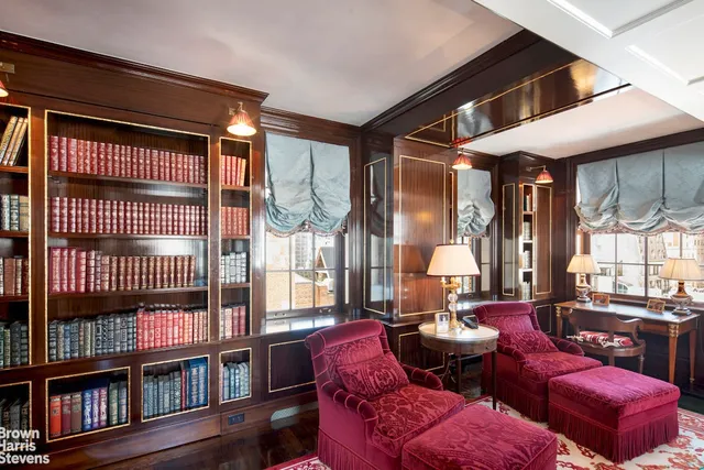 a living room with furniture a large window and red walls