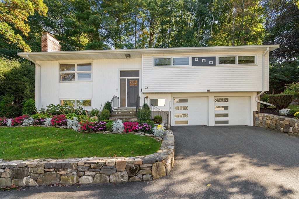 28 Woodbine Circle Needham, MA 02494 - Photo 1 of 29 a front view of a house with a garden and plants