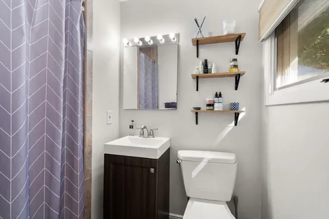 a bathroom with a sink a toilet and mirror