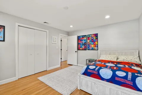 a bedroom with a bed a mirror and dresser