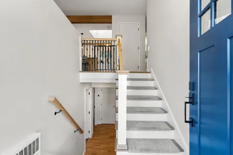 a view of entryway with wooden floor and a front door