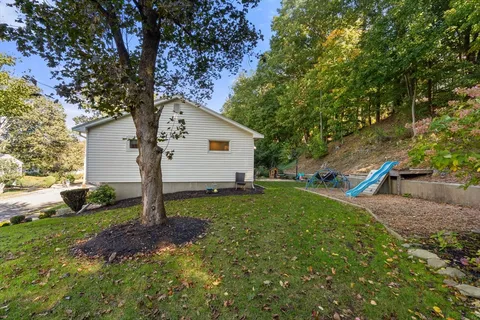 a house is sitting in middle od the grass