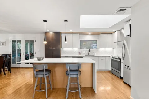 a kitchen with refrigerator cabinets dining table and chairs