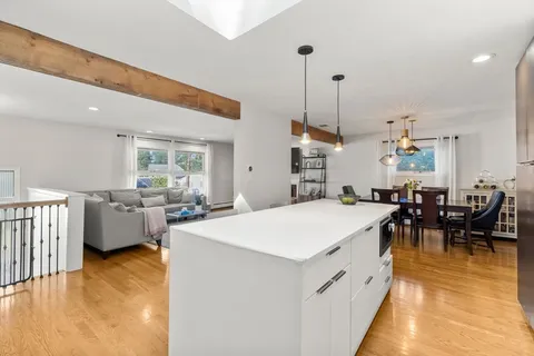 a large kitchen with a table chairs and a wooden floor