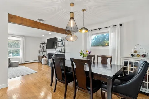 a view of a dining room and livingroom with furniture wooden floor a chandelier