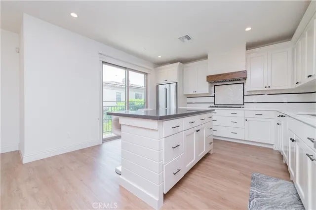a large kitchen with granite countertop a sink stainless steel appliances and cabinets