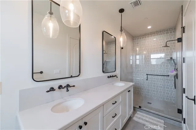 a bathroom with a sink vanity granite shower and a mirror